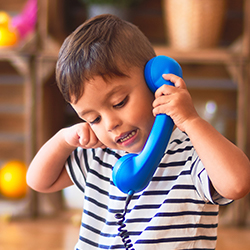 young boy talking on pretend phone