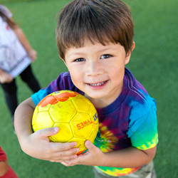 boy smiling holding soccer ball