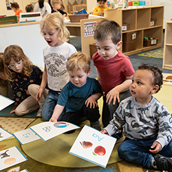 kids on the carpet looking at large flashcards