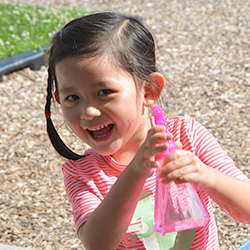 Young girl playing outside at splash table