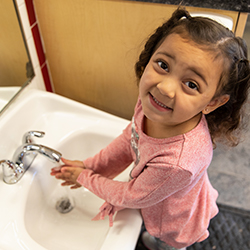 young girl washing her hands