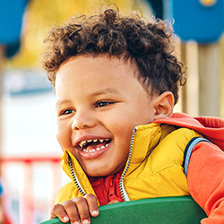 young boy smiling on playset